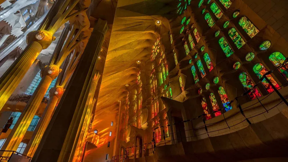 Guided group crossing the nave under coloured light on an express entry la sagrada familia tour in Barcelona